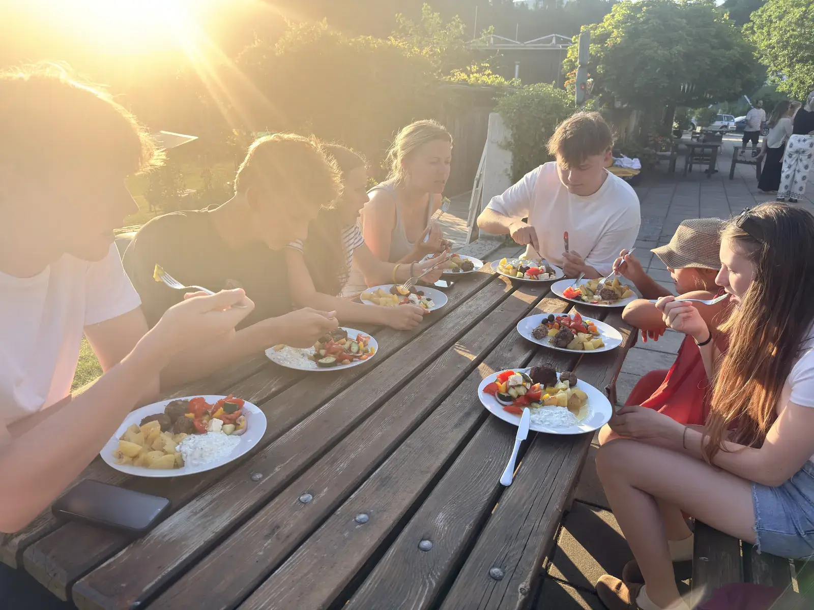 Participantes cenando juntos en una mesa al aire libre